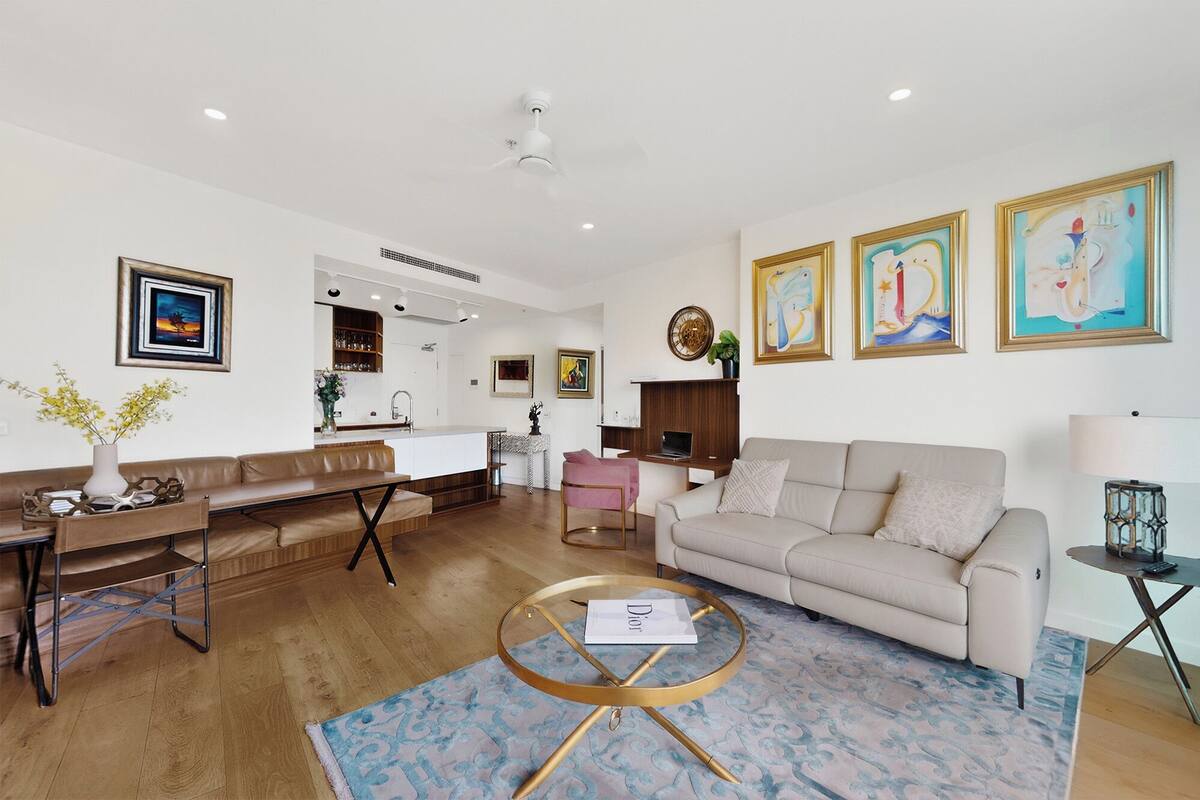 A modern living room with a sofa, coffee table, and artwork on the walls.