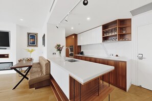Una cocina moderna con una isla central, armarios de madera y una estantería empotrada para vinos.