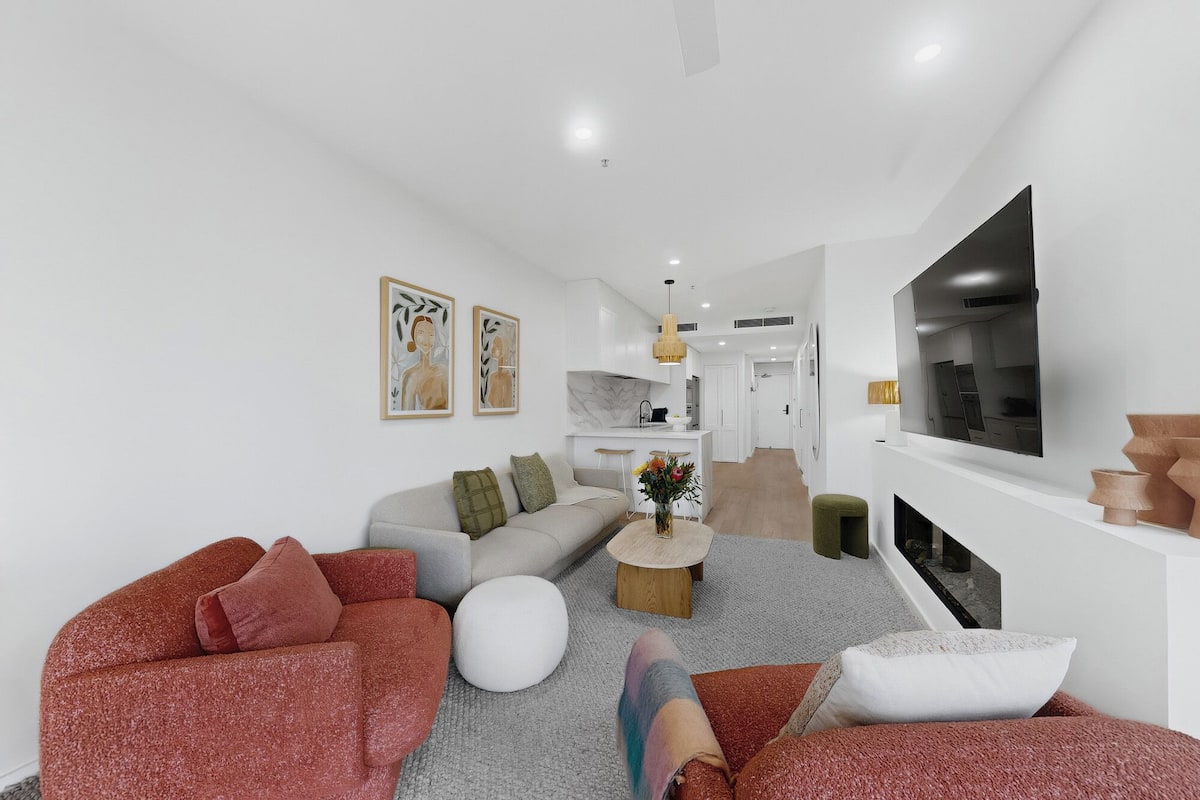 A modern living room with a sofa, coffee table, and artwork on the walls.