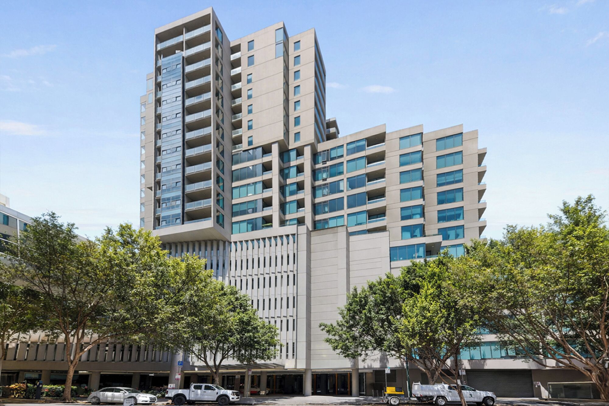 A multi-story building with a modern architectural design, featuring a mix of glass and concrete facades.