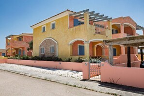 Ein zweistöckiges Gebäude mit gelber Fassade, gewölbten Fenstern und einem verschlossenen Eingang.