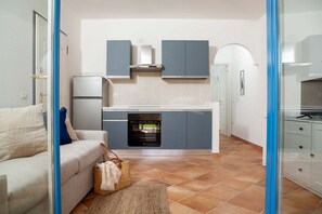 A compact kitchen with grey cabinets, a built-in oven, and a white countertop. - Leone II Apartment (4 guests) - FREE parking   (Santa Teresa Gallura)