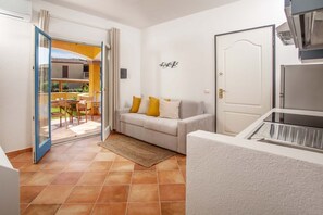 Un salon avec un canapé, une porte et une vue sur un espace extérieur.