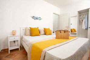 Ein Schlafzimmer mit Bett, Nachttisch, Korb, Kleiderschrank und Wanddekoration.