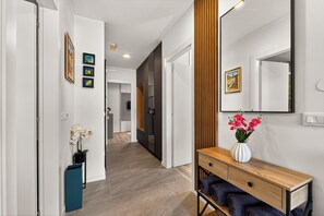 A hallway with a wooden bench, a mirror, and framed pictures on the wall. - Alba Azzura 2-bedroom apartment in Zaton (Zaton)