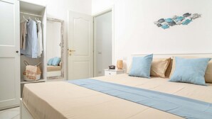 Un dormitori amb un llit, un armari, una taula de nit i una decoració mural.