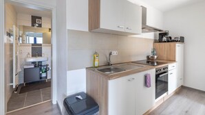 A modern kitchen with a sink, stove, and cabinets. - Cozy Apartment in the Heart of Heidenheim an der Brenz (Heidenheim)