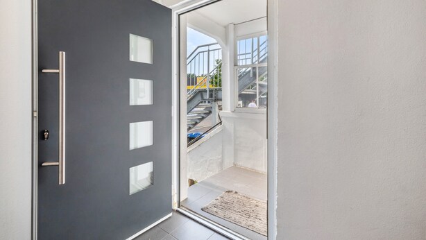 A modern door with a handle, glass panels, and a view of a staircase leading outside. - Cozy Apartment in the Heart of Heidenheim an der Brenz (Heidenheim)