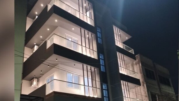 A multi-story building with balconies, large windows, and a sign that reads 'PONTMAN.'