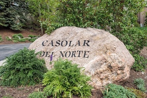 Ein großer Felsen mit der Inschrift 'CASOLAR DEL NORTE', umgeben von Grün.