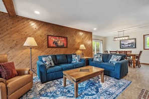 A living room with two sofas, a coffee table, and a dining area with a table and chairs. - Vail Casolar - Indoor Hot Tub (Vail)