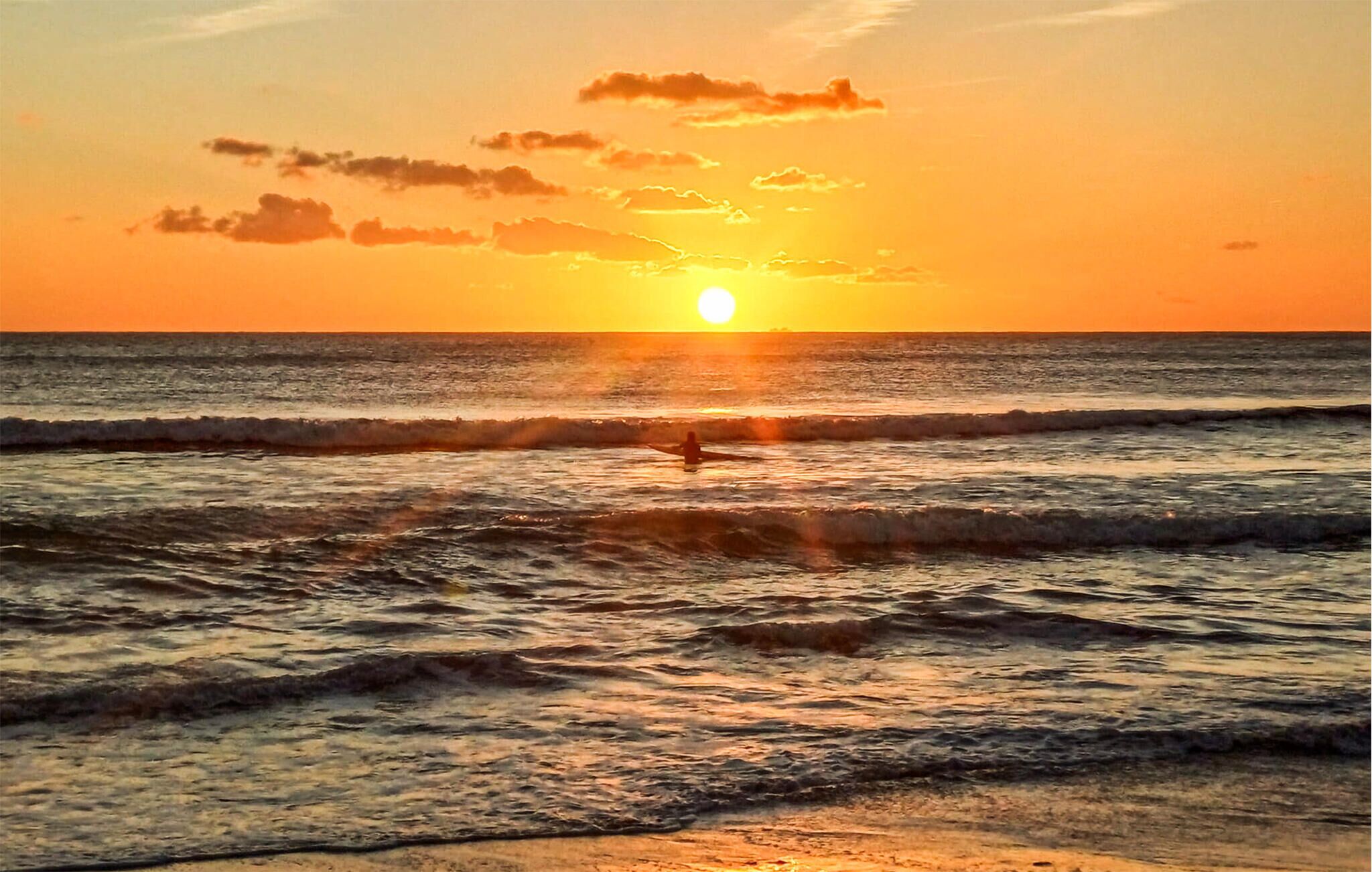 Un atardecer sobre el océano con olas.