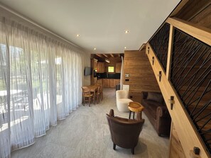 Ein modernes Interieur mit Essbereich, Küche und Treppe.