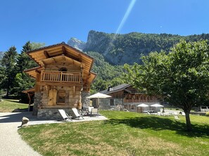 Eine Holzhütte mit Balkon, Stein Fundament und Bergblick.