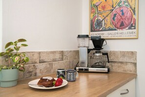 A kitchen counter with a coffee maker, a scale, and a plate with food. - Retro home with three terraces near the beach (Glesborg)