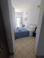 Habitación estándar doble, balcón, vistas parciales al mar | Caja fuerte, cortinas opacas, tabla de planchar con plancha