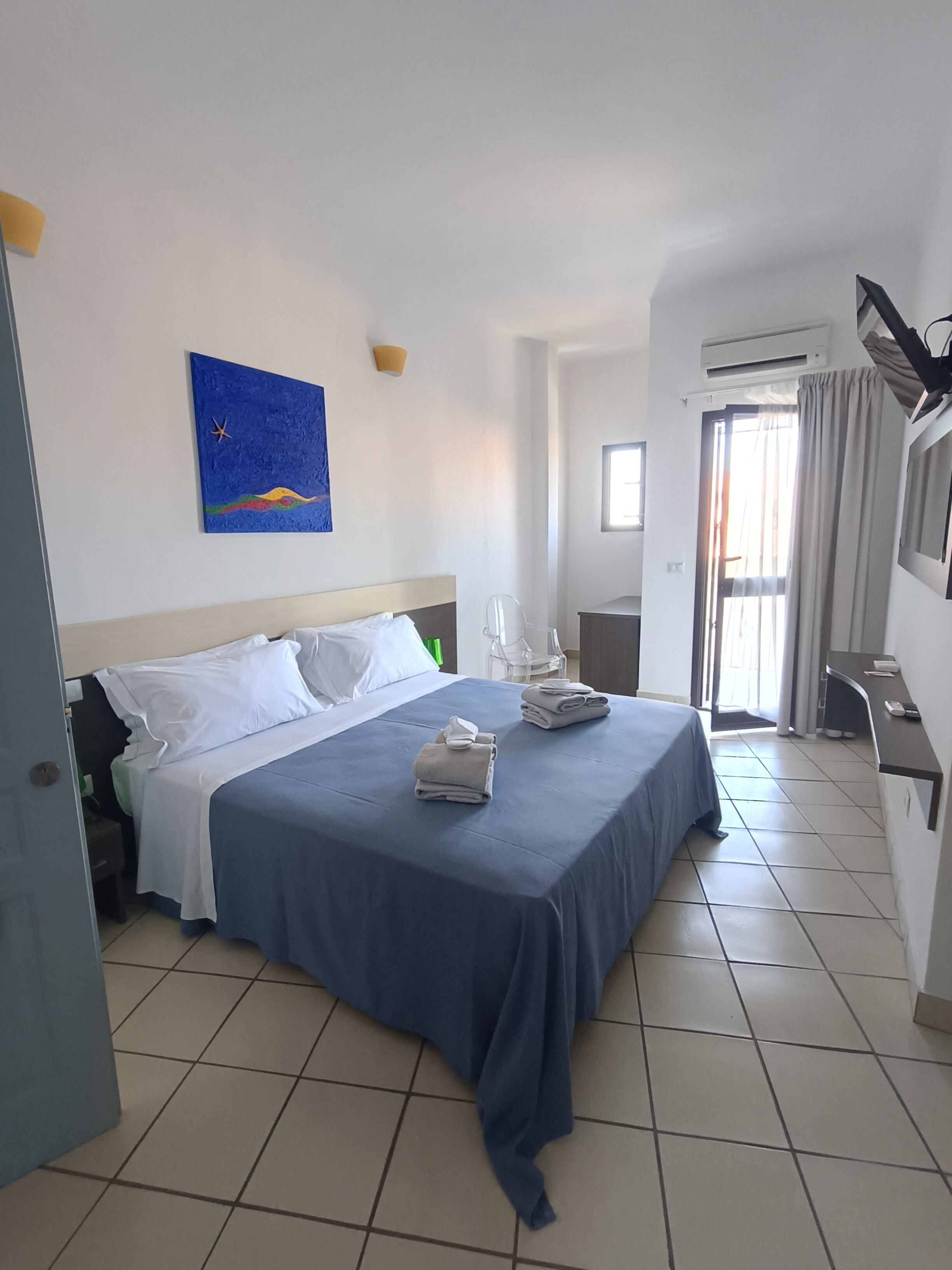 Suite junior, balcón, vistas parciales al mar | Caja fuerte, cortinas opacas, tabla de planchar con plancha