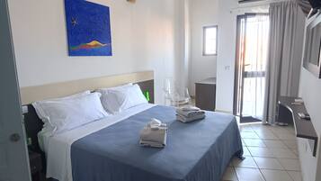 Suite junior, balcón, vistas parciales al mar | Caja fuerte, cortinas opacas, tabla de planchar con plancha