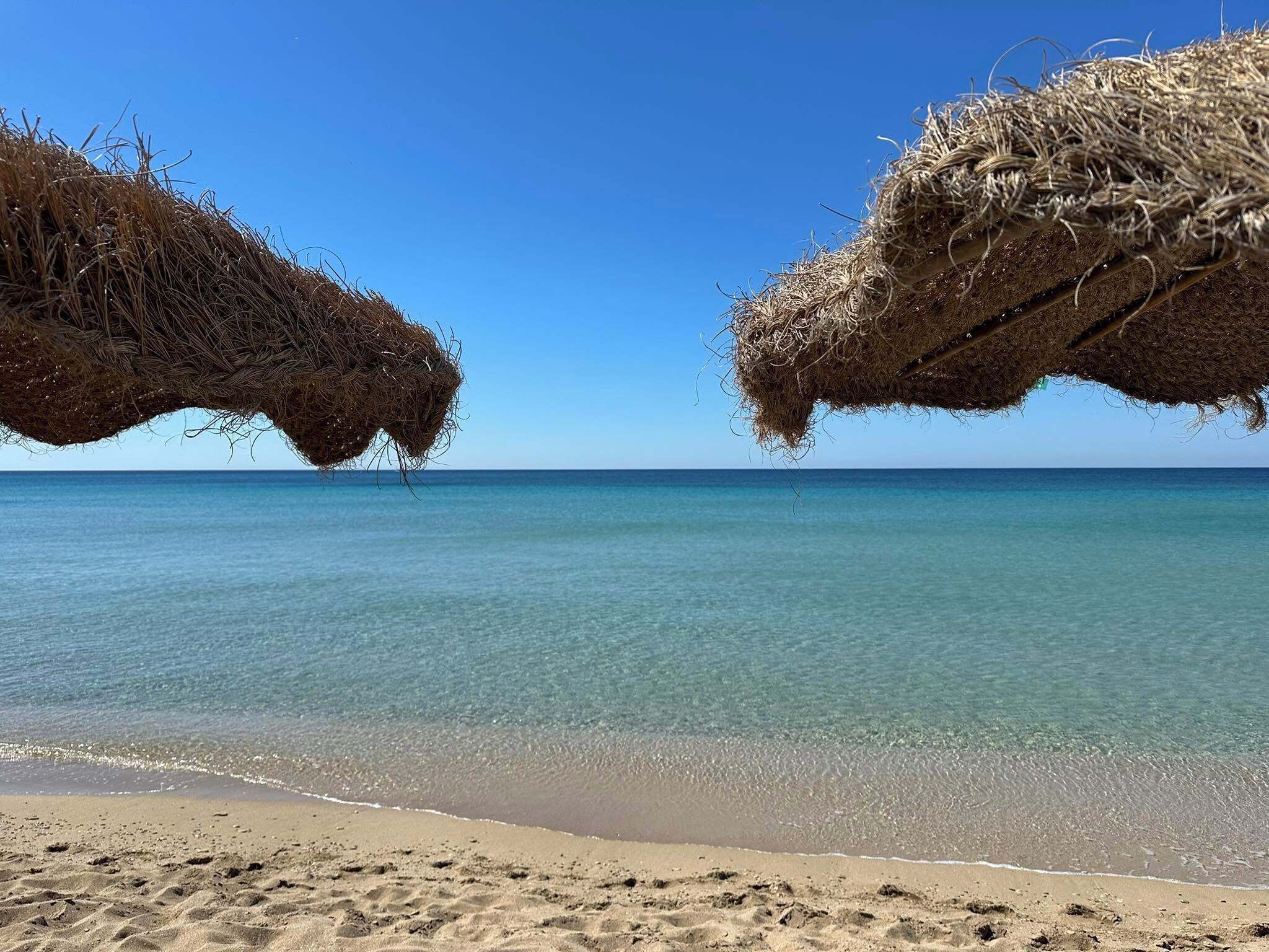 Una spiaggia con acque cristalline e una riva sabbiosa.