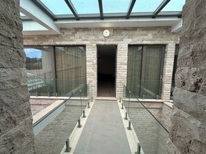 Een modern gebouw met een gevel van natuursteen, grote glasramen en een centrale deur.