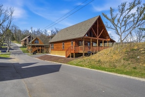 A log cabin with a porch, a covered deck, and a steep driveway. - Morning Glory (Sevierville)