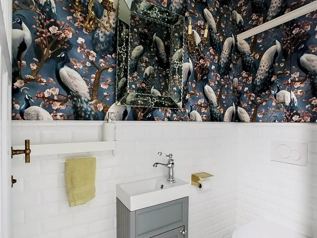 A bathroom with a white tiled wall, a mirror, a sink with a faucet, and a towel rack.