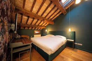 A bedroom with a wooden ceiling, a bed, bedside tables, and a small table with glasses. - Vrbo Property (Noale)