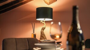 Una mesa de comedor con una lámpara decorativa, una copa de vino y una botella.