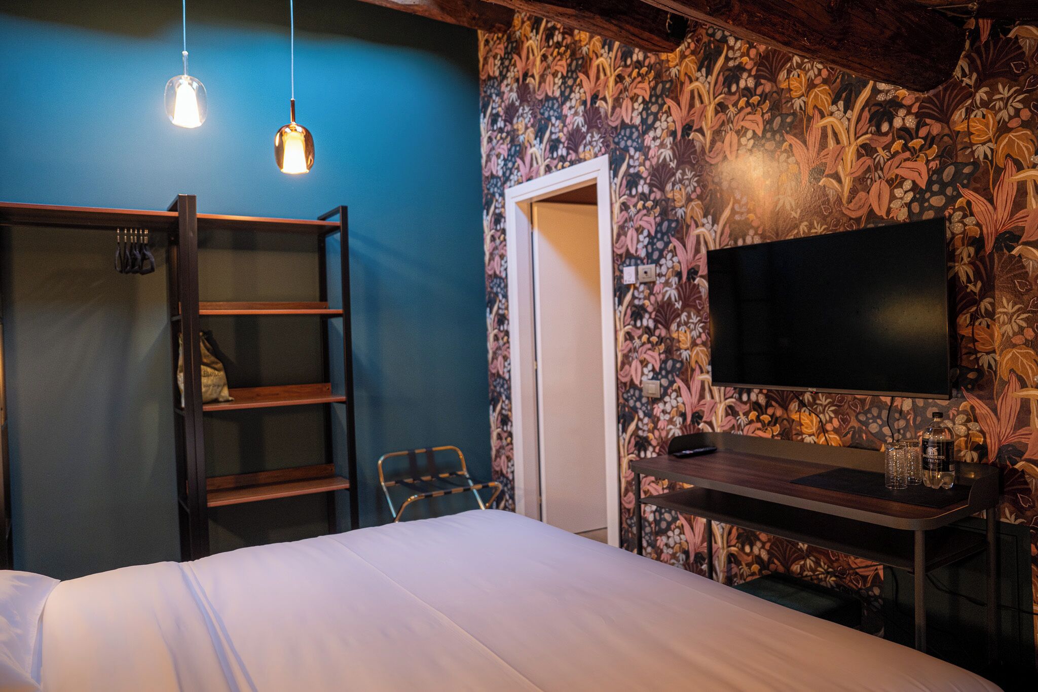 Une chambre à coucher comprenant un lit, un bureau, une chaise, un téléviseur et une armoire.
