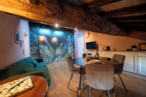 A modern living space with a dining area, kitchen, and a large wall mural. - Vrbo Property (Noale)