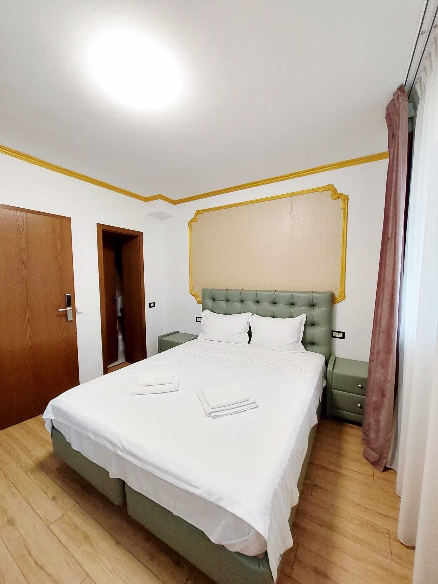 Ein Schlafzimmer mit Bett, Nachttischen, einem Kleiderschrank und einem Spiegel.
