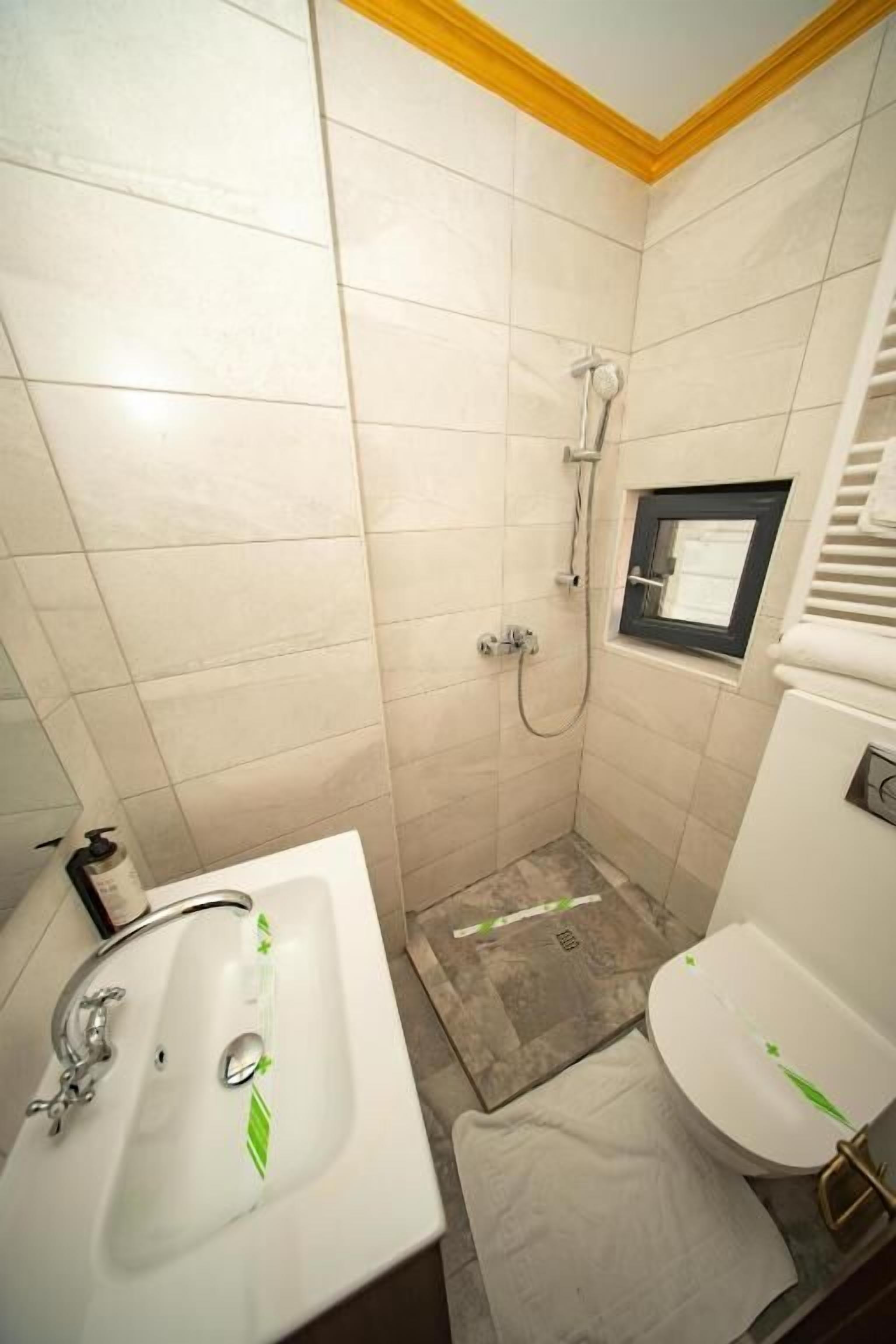 Een badkamer met een douche, toilet en wastafel.