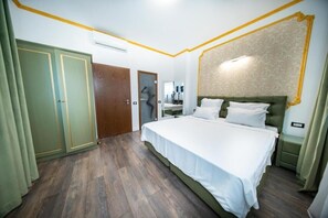 Un dormitorio con cama, armario, espejo y mesita de noche.