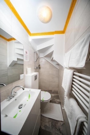 Un baño con lavamanos, inodoro y perchero para toallas.