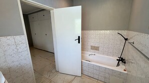 Ein Badezimmer mit einer Badewanne, einer Dusche und einem WC.