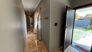 Un corridoio con una porta in vetro che dà su un balcone.