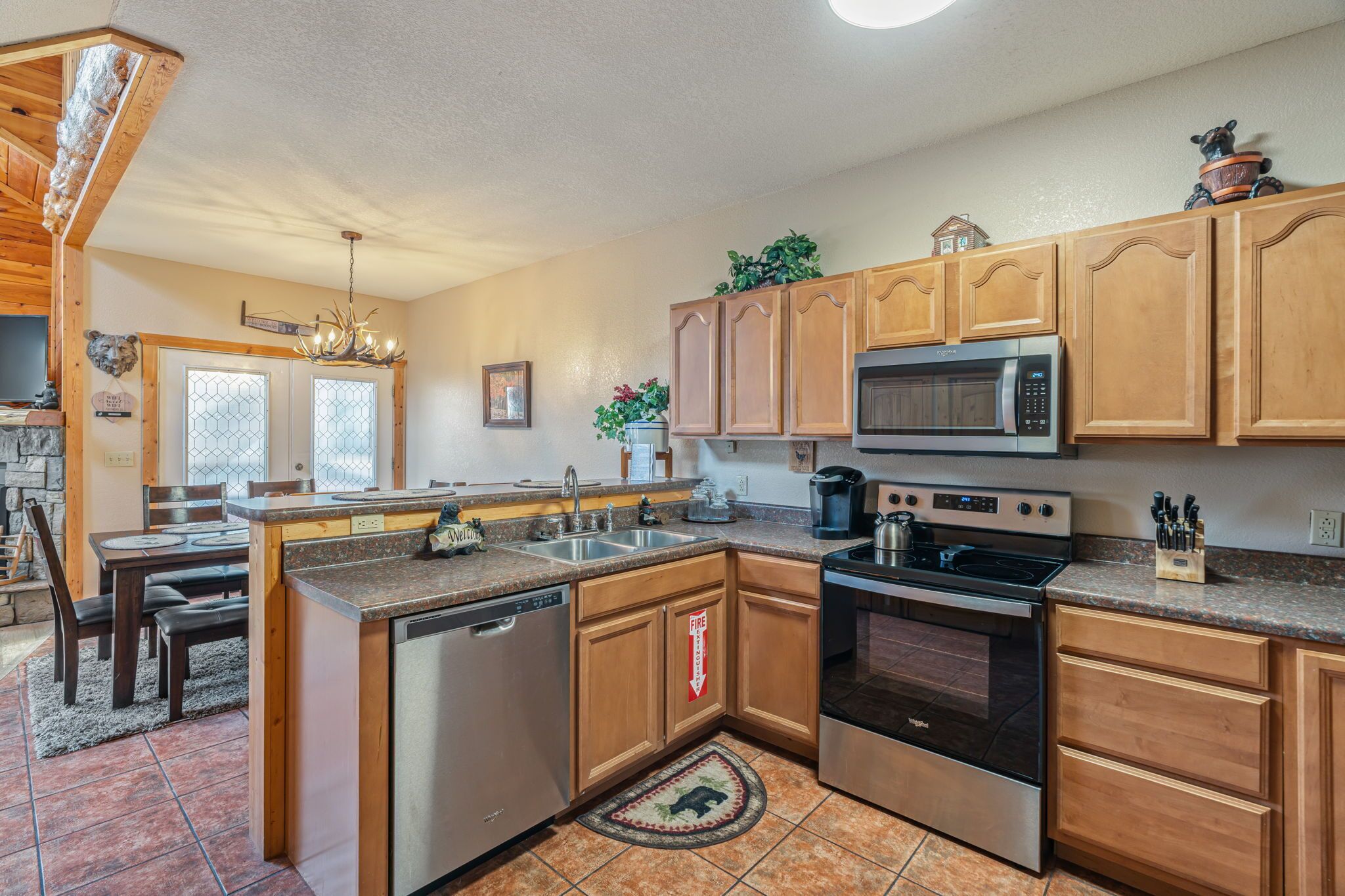 A modern kitchen with wooden cabinets, stainless steel appliances, and a granite countertop.