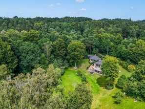 A house surrounded by dense forest, with a well-maintained lawn and a clear sky. - "Berenice" - 500m from the sea by Interhome (Ebeltoft)
