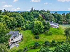 A residential property with a large lawn, a house with a balcony, and a view of the sea. - "Berenice" - 500m from the sea by Interhome (Ebeltoft)