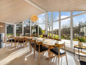 A modern dining area with large windows, wooden furniture, and a unique ceiling sculpture. - "Berenice" - 500m from the sea by Interhome (Ebeltoft)