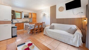 A compact living space with a kitchenette, dining area, and a sofa. - Apartment "Le Soleil des Alpages" with Mountain View (Slopes) and Balcony (La Plagne-Tarentaise)