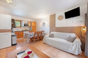 A compact living space with a kitchenette, dining area, and a sofa.