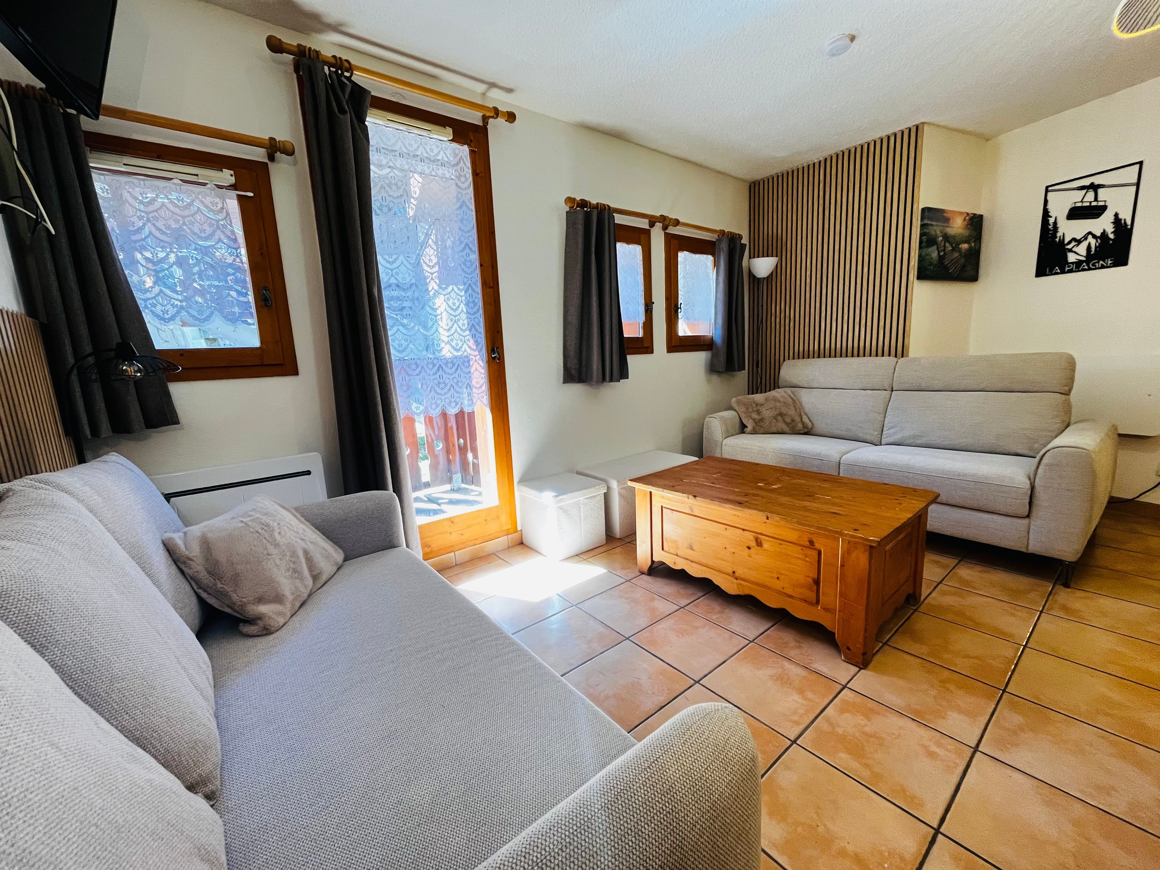 A living room with a sofa, a wooden coffee table, and a light-colored couch.
