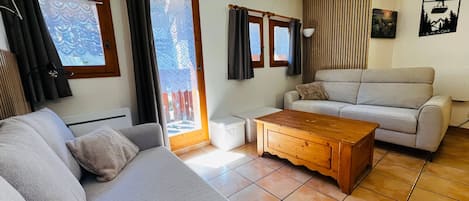 A living room with a sofa, a wooden coffee table, and a light-colored couch.