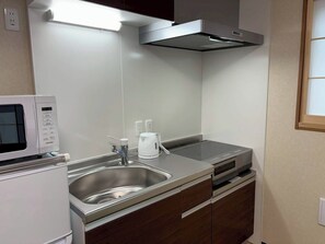 A modern kitchen with a built-in microwave, stainless steel sink, and a coffee maker. - Newly Opened Right Next to JR Kamata Station: YU'S HOUSE 2 (大田区)