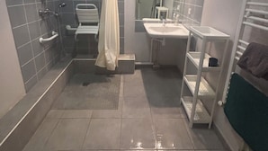 Une salle de bain équipée d’une douche, de toilettes, d’un lavabo et d’un porte-serviettes.