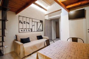 Ein gemütliches Zimmer mit einer Couch, einem Tisch und einem Wandbild.