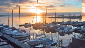 A marina with boats docked, a sunset in the background, and a distant pier. - Gorgeous home in Uitgeest with house sea view (Uitgeest)