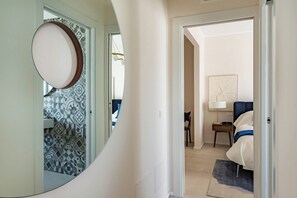A hallway leading to a bedroom with a bed, a bedside table, and a lamp. - Dimora Italia in the Centre Bari (Bari)