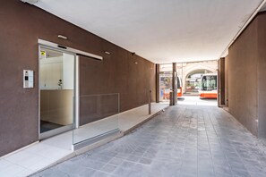 A corridor with a glass elevator door, a tiled floor, and a bus in the background. - Dimora Italia in the Centre Bari (Bari)